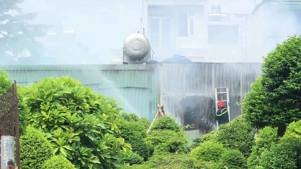 Lực lượng chuyên nghiệp đục vách tôn để dập lửa bên trong. Ảnh: HT Lực lượng chuyên nghiệp đục vách tôn để dập lửa bên trong. Ảnh: HT