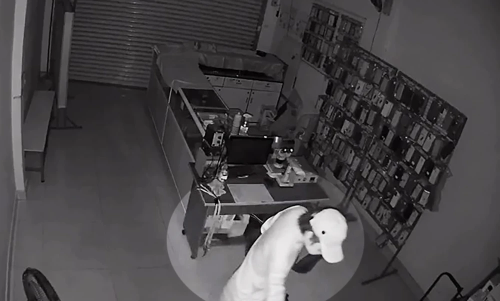 Người đàn ông đột nhập vào tiệm điện thoại trên địa bàn quận 12 lấy đi hàng chục điện thoại. Ảnh cắt từ clip