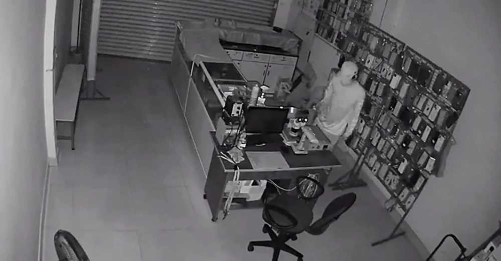 Người đàn ông sau đó dùng ghế để leo lên, tẩu thoát lên mái nhà. Ảnh cắt từ clip