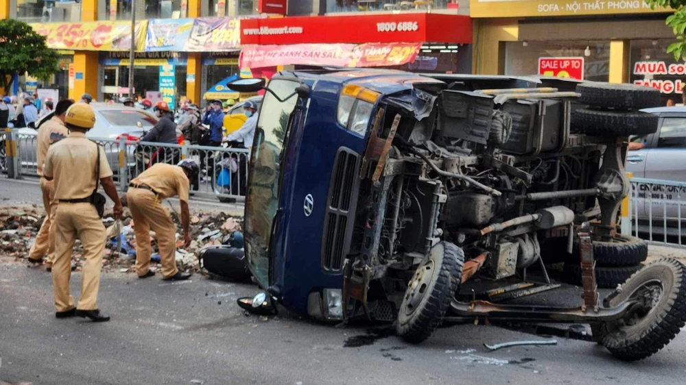 Chiếc xe ben đang lưu thông trên đường thì tông dải phân cách, lật đè trúng một xe máy. Ảnh: HT