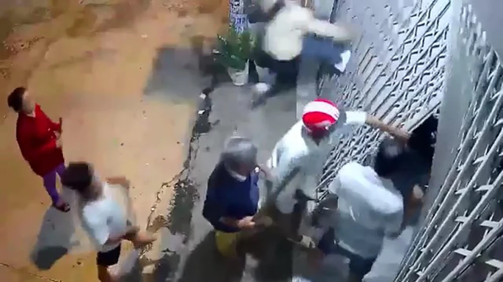 Nhóm người trong gia đình ông Phước cầm gậy gộc đập phá cửa, xông vào nhà. Ảnh cắt từ clip