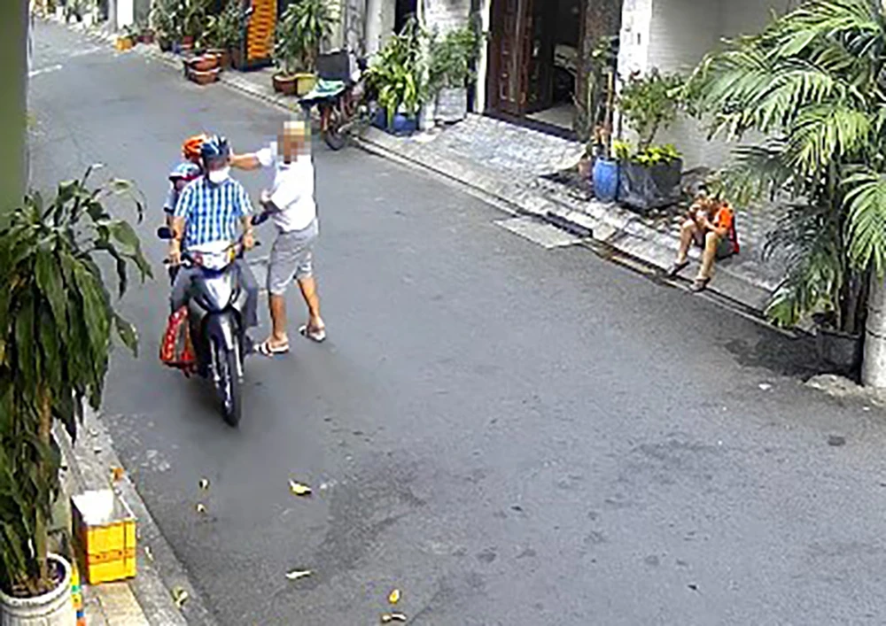 Chồng chị Hoàng A bị người hàng xóm kiếm chuyện, đánh vào đầu khi đang di chuyển trên đường. Ảnh cắt từ clip