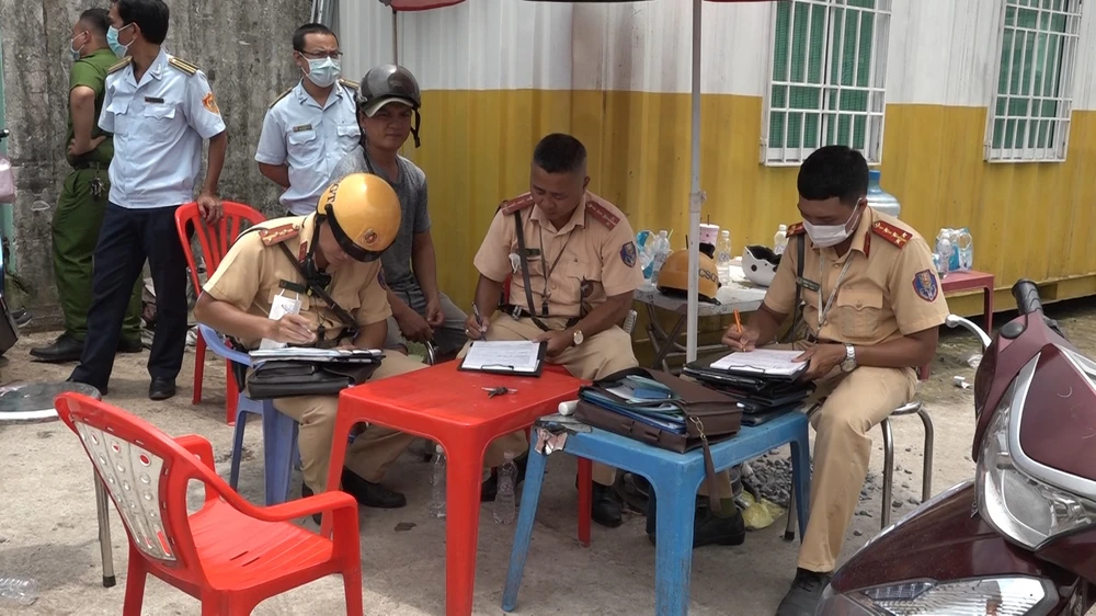 Công an huyện Hóc Môn xử lý các trường hợp vi phạm tại khu vực Chợ đầu mối. Ảnh: NT