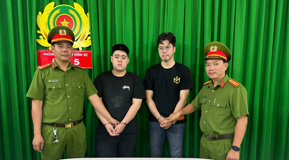 Quân (áo đen, bên trái) tại cơ quan điều tra. Ảnh: CA