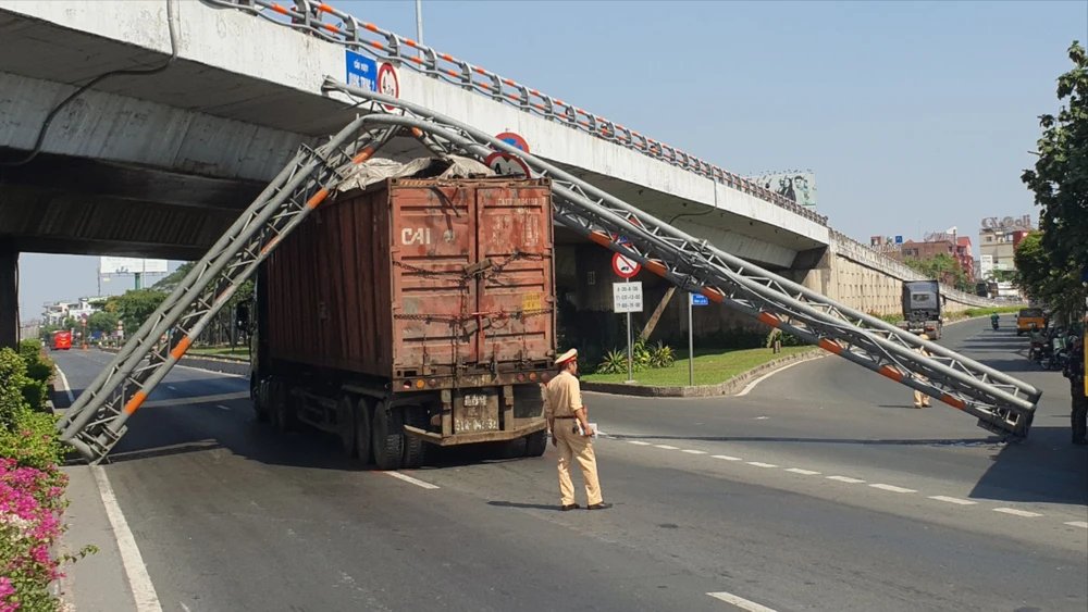 Xe đầu kéo kéo gãy giá long môn trên Quốc lộ 1 rồi va trúng xe buýt