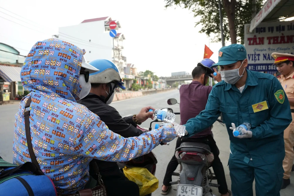 Hàng trăm người dân về quê nghỉ lễ được tặng nón bảo hiểm, nước suối ở Bình Chánh