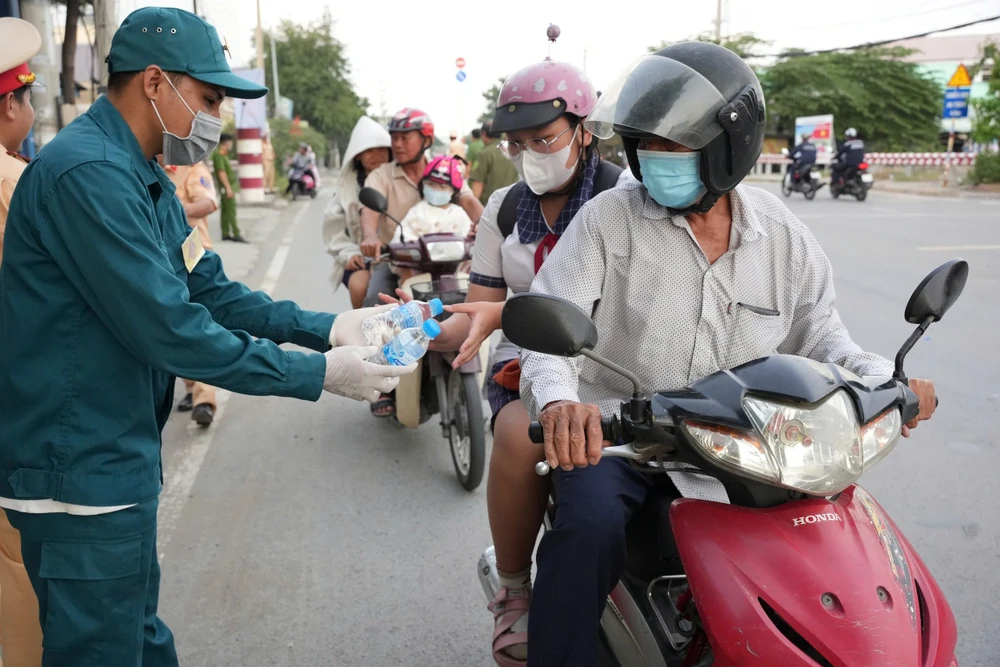 Hàng trăm người dân về quê nghỉ lễ được tặng nón bảo hiểm, nước suối ở Bình Chánh