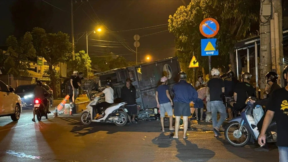 Xe tải đang chạy bị lật đè xe máy, 2 người thoát chết trong đêm