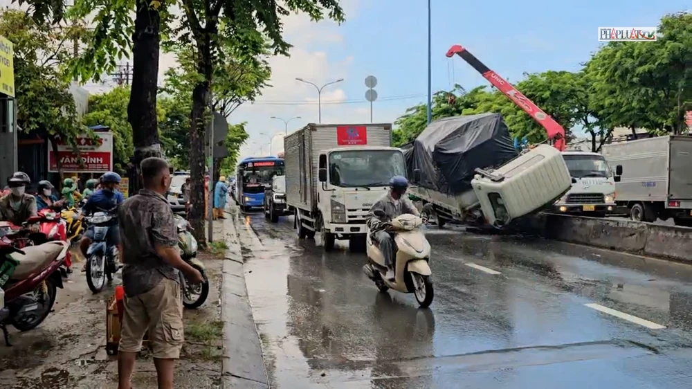 Xe tải lật ngang trên đường Trần Văn Giàu, giao thông ùn ứ trong mưa