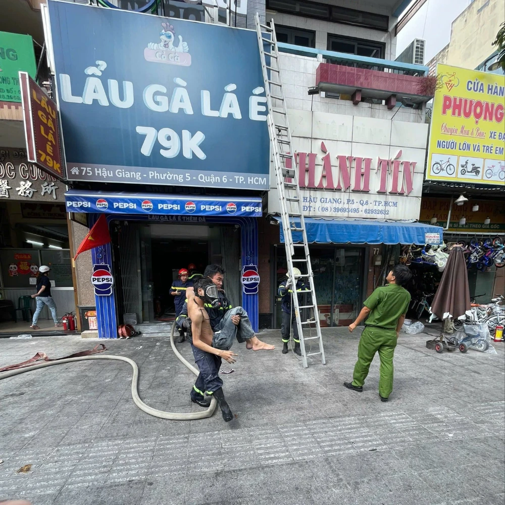Cảnh sát tiếp cận giải cứu người mắc kẹt bên trong tiệm lẩu gà. Ảnh: CA