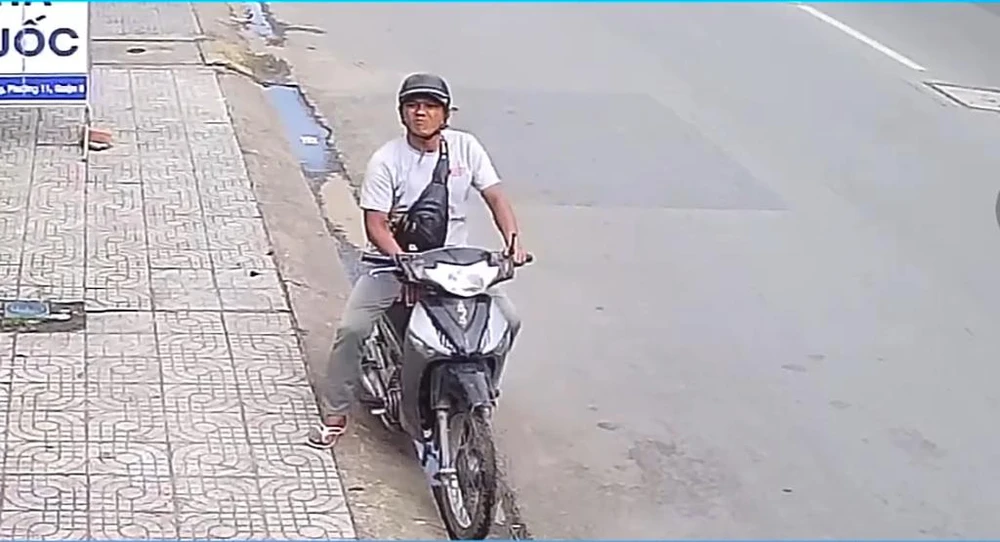 Hình ảnh nghi phạm xuất hiện trước cửa hàng nạn nhân làm việc. Sau đó, người này bỏ lại chiếc xe máy Future Neo đang sử dụng ở hiện trường. Ảnh cắt từ clip
