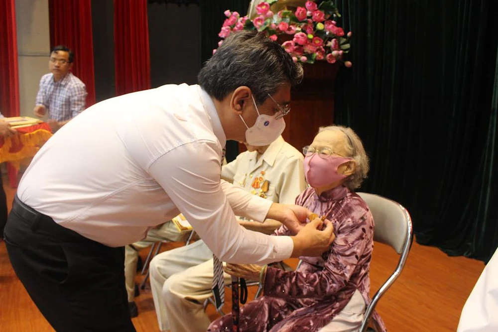 Ông Nguyễn Phước Lộc, Trưởng Ban tổ chức Thành uỷ trao Huy hiệu Đảng cho một Đảng viên 75 năm tuổi Đảng. Ảnh: NGUYỄN YÊN