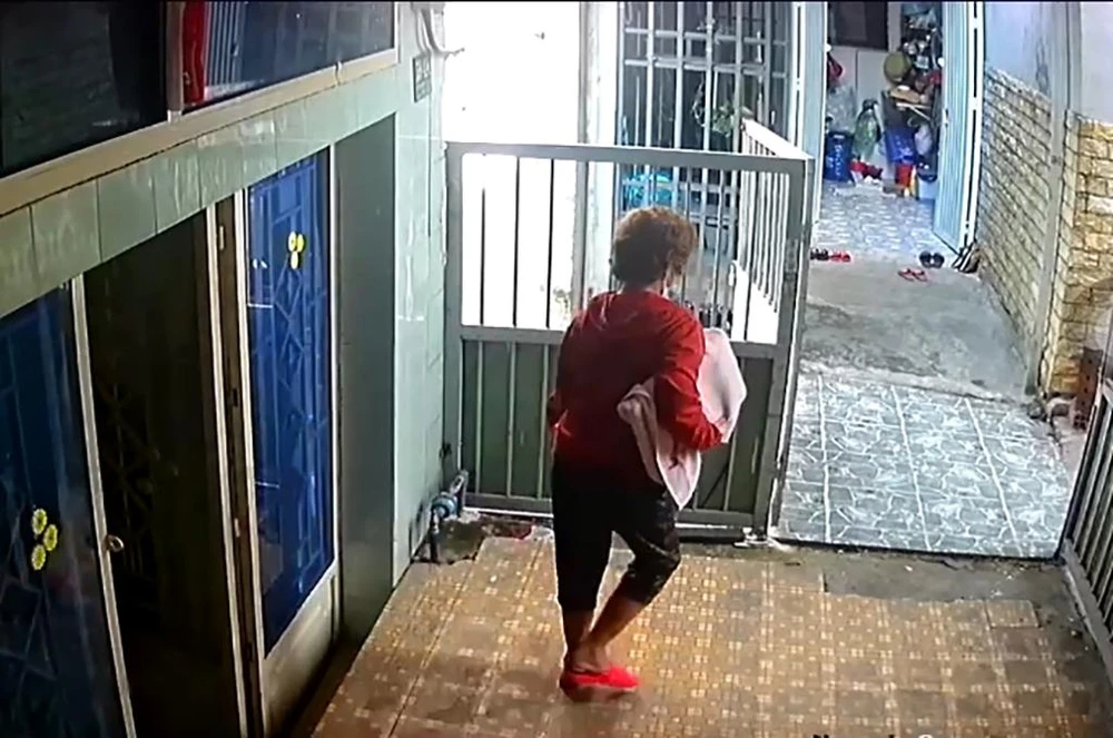 Mang chiếc laptop được quấn trong khăn rời đi. Ảnh: Cắt từ clip