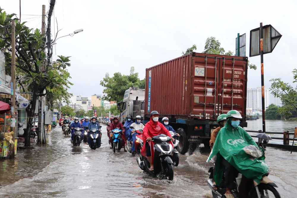 Xe container di chuyển tạo sóng đánh vào người đi xe máy. Ảnh: ĐC