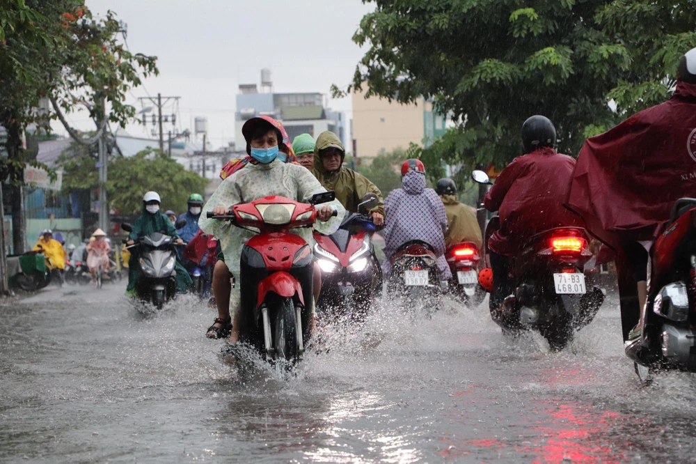 Người dân vất vả di chuyển do triều cường dâng cao. Ảnh: ĐC