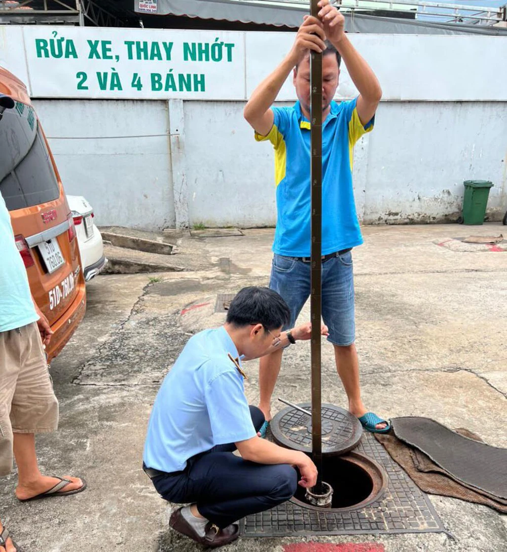 Lực lượng Quản lý thị trường đo bồn tại một cây xăng trên địa bàn TP.HCM. Ảnh: QLTT