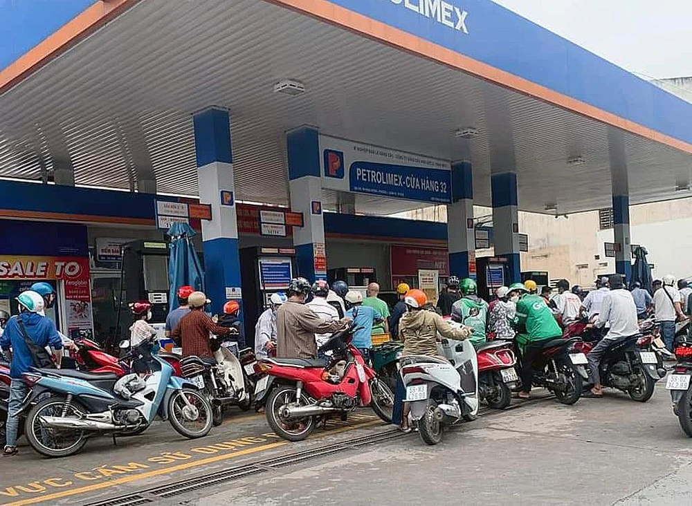 Hàng chục người dân chờ đợi mua xăng tại một cây xăng ở quận 1. Ảnh: NY