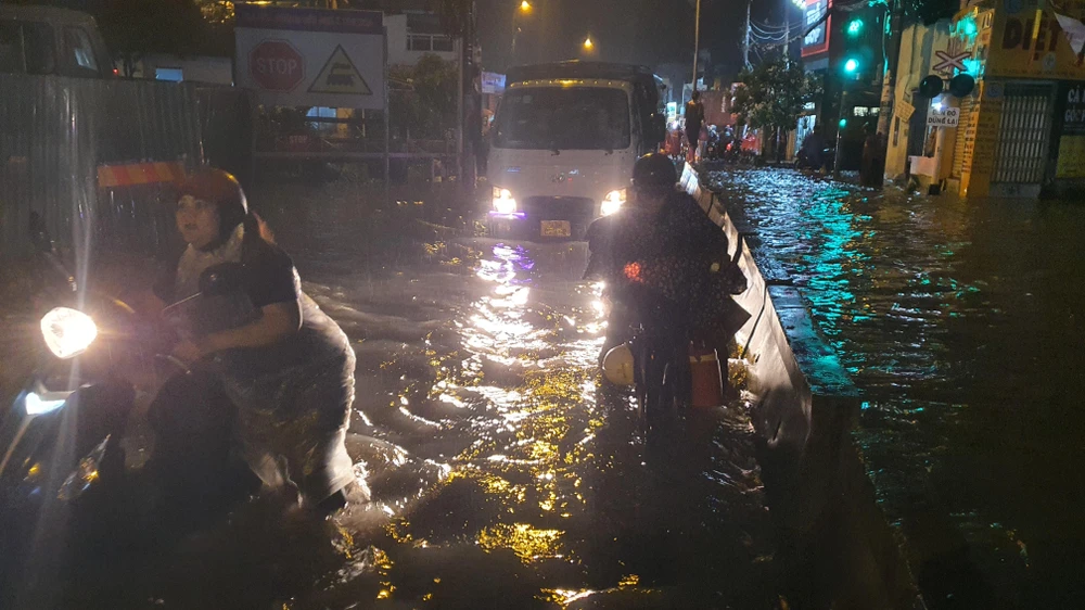 Chị NTH (ngụ đường Tam Bình) bất lực dắt chiếc xe chết máy qua đoạn đường ngập và cho biết: "Bây giờ đi đoạn Linh Đông vào cũng ngập, xung quanh chỗ nào về nhà cũng ngập. Đường này chỉ cần mưa một tý là ngập".