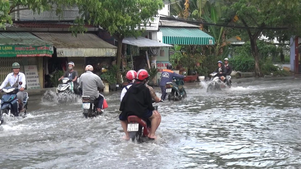 Người dân di chuyển vất vả trong nước lớn do triều cường. Ảnh: ĐC
