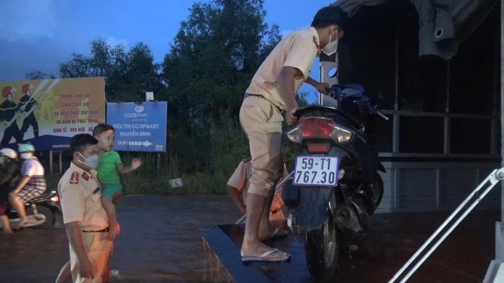 CSGT đưa trẻ em qua đoạn nước ngập. Ảnh: ĐC