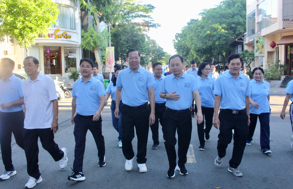 Lãnh đạo TP.HCM và lãnh đạo quận tham gia chương trình đi bộ gây quỹ ủng hộ người khó khăn. Ảnh: NGUYỄN YÊN