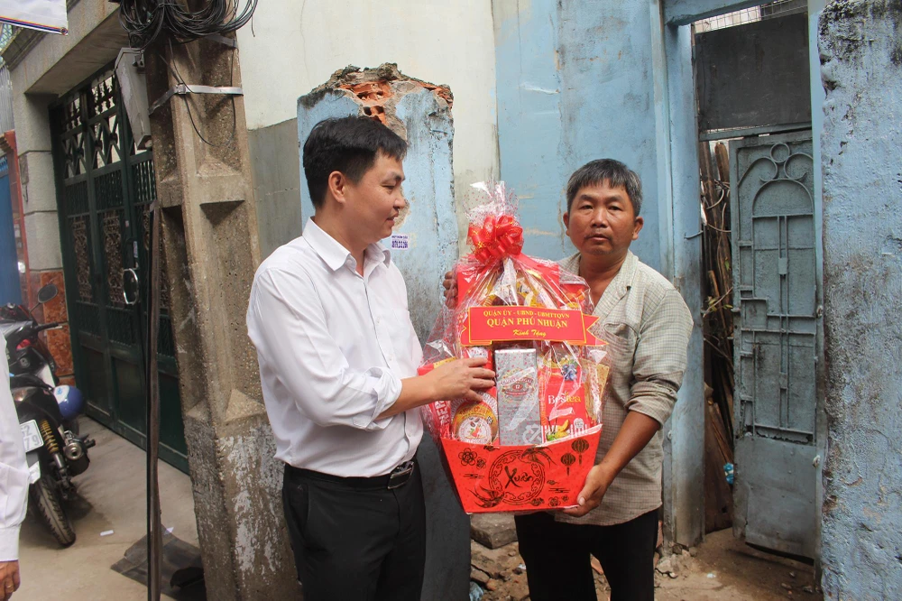 Ông Trần Quang Sang, Phó Chủ tịch UBND quận Phú Nhuận trao quà cho một hộ dân khó khăn tại hẻm. Ảnh: NGUYỄN YÊN