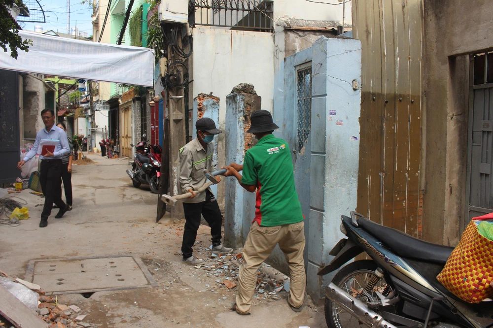 Đội thợ đang thực hiện việc tháo dỡ tại hẻm 694 Nguyễn Kiệm vào sáng 5-12. Ảnh: NGUYỄN YÊN