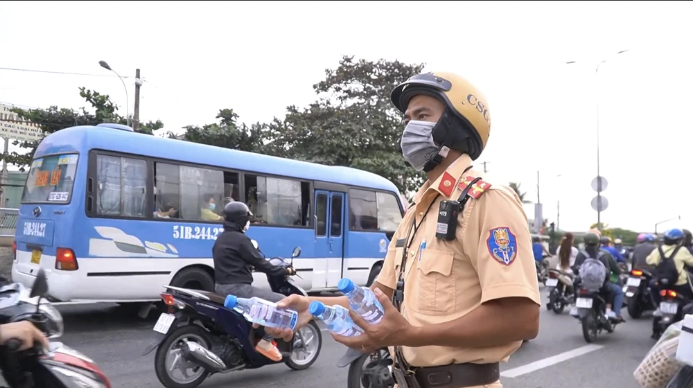 CSGT phát nước suối cho người dân về quê. Ảnh: ĐC