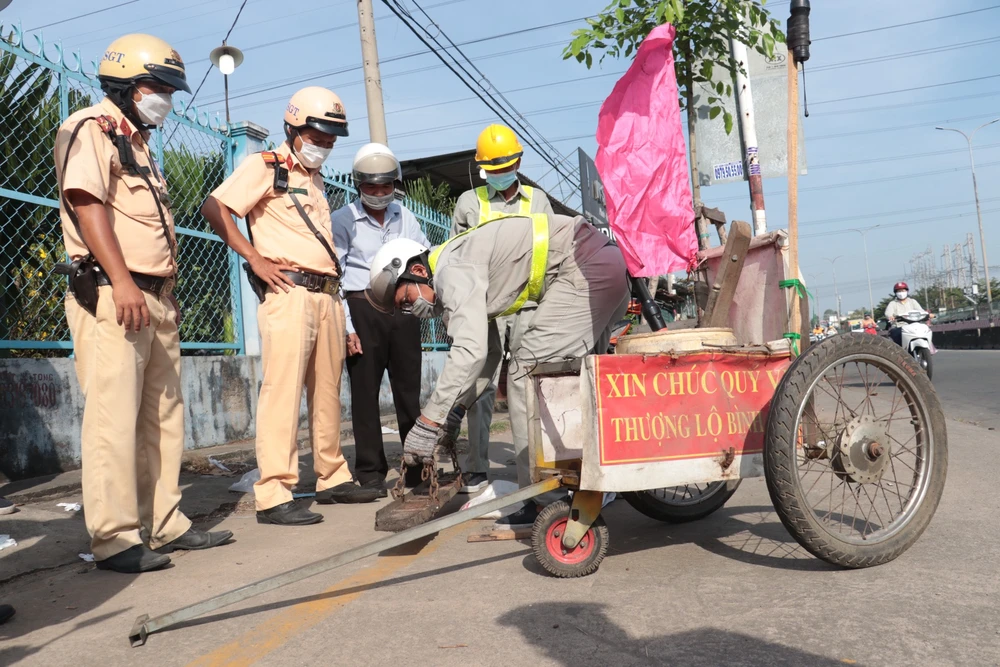 CSGT phối hợp với các đơn vị tiến hành hút đinh trên Quốc lộ 1. Ảnh: PC08