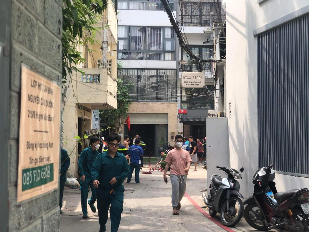 Kéo dây nước từ đầu hẻm vào để chữa cháy. Ảnh: ĐC