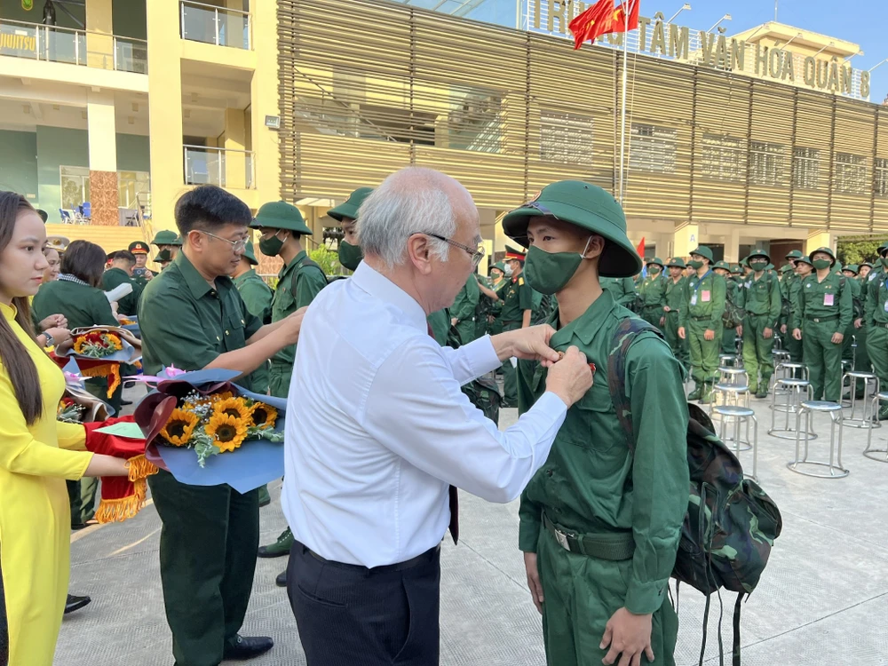 Ông Phan Nguyễn Như Khuê, Trưởng ban Tuyên giáo Thành ủy TP.HCM, trao huy hiệu cho công dân tham gia NVQS. Ảnh: NGUYỄN YÊN