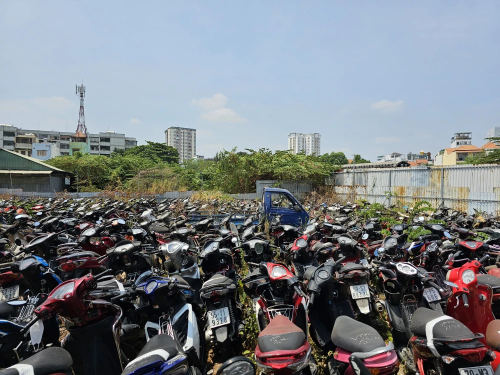 Hàng trăm phương tiện chủ yếu là xe máy nằm trong tình trạng phơi nắng giữa một khu đất trống, không bóng cây.