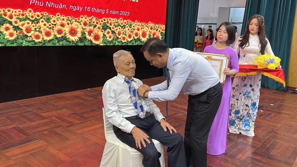 Chủ tịch UBND quận Phú Nhuận trao huy hiệu 70 năm tuổi Đảng cho đảng viên. Ảnh: NY Chủ tịch UBND quận Phú Nhuận trao huy hiệu 70 năm tuổi Đảng cho đảng viên. Ảnh: NY