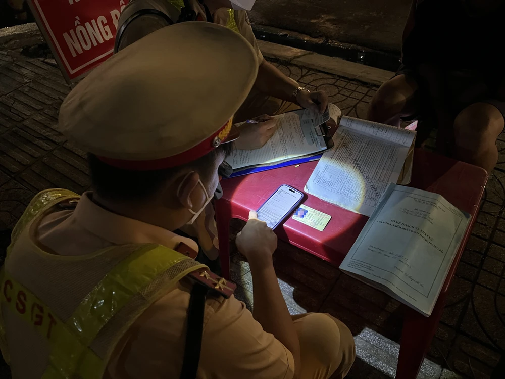 CSGT kiểm tra bằng lái xe của tài xế M. và phát hiện đây là bằng lái giả. Ảnh: NGUYỄN YÊN
