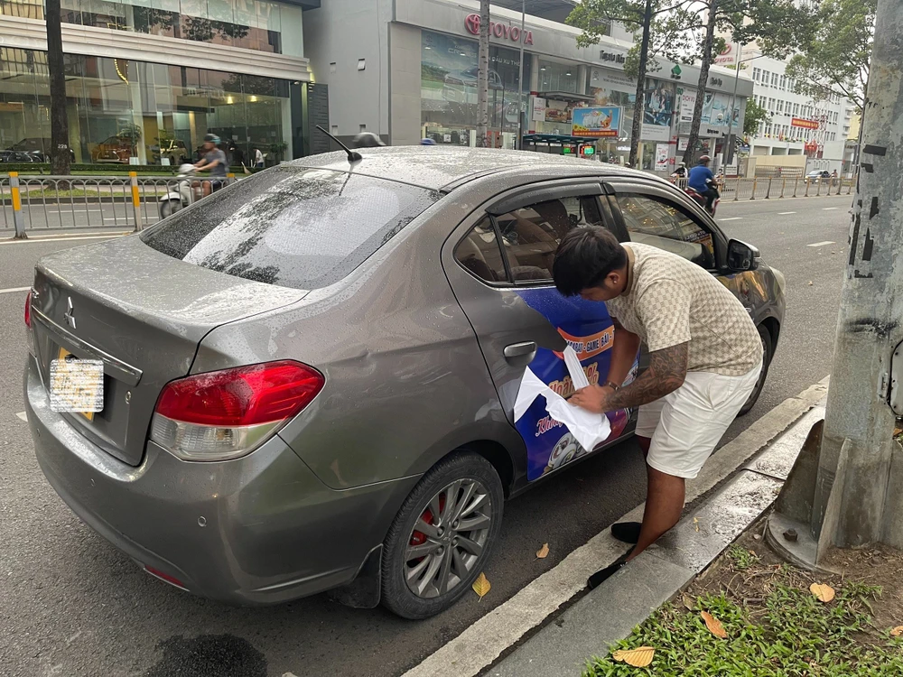 Lực lượng chức năng buộc tài xế tháo quảng cáo vi phạm. Ảnh: PC08 Lực lượng chức năng buộc tài xế tháo quảng cáo vi phạm. Ảnh: PC08