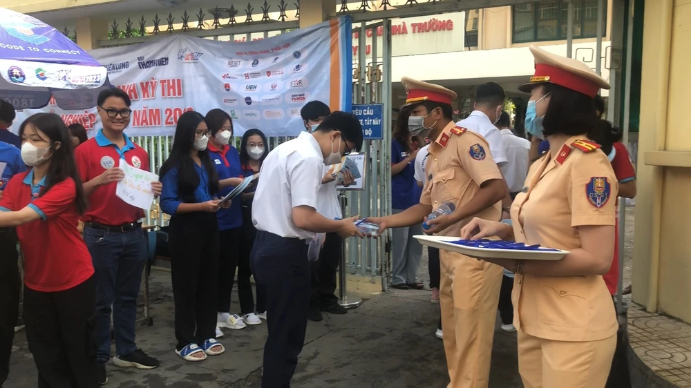 CSGT tặng nước suối, bút cho các thí sinh kỳ thi THPT Quốc gia tại điểm trường THPT Hùng Vương, quận 5. Ảnh: NGUYỄN YÊN