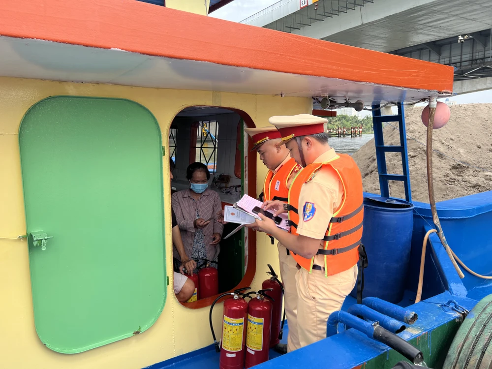 Kiểm tra giấy tờ, chứng chỉ, dụng cụ trên một sà lan. Ảnh: NGUYỄN YÊN