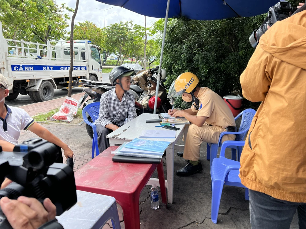 CSGT lập biên bản vi phạm đối với ông H. Ảnh: NGUYỄN YÊN