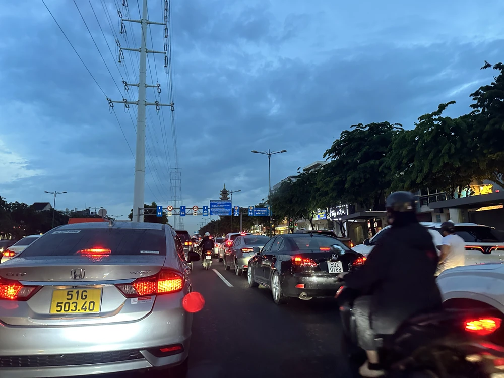 Người đi xe máy len lỏi vào giữa các xe ô tô để di chuyển. Người đi xe máy len lỏi vào giữa các xe ô tô để di chuyển.