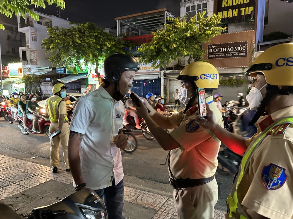 CSGT kiểm tra nồng độ cồn một người dân. Ảnh: NGUYỄN YÊN