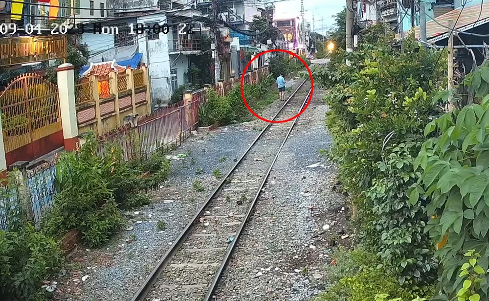 Hình ảnh ông D. đi bộ sát đường ray thời điểm trước lúc xảy ra tai nạn. Ảnh cắt từ clip