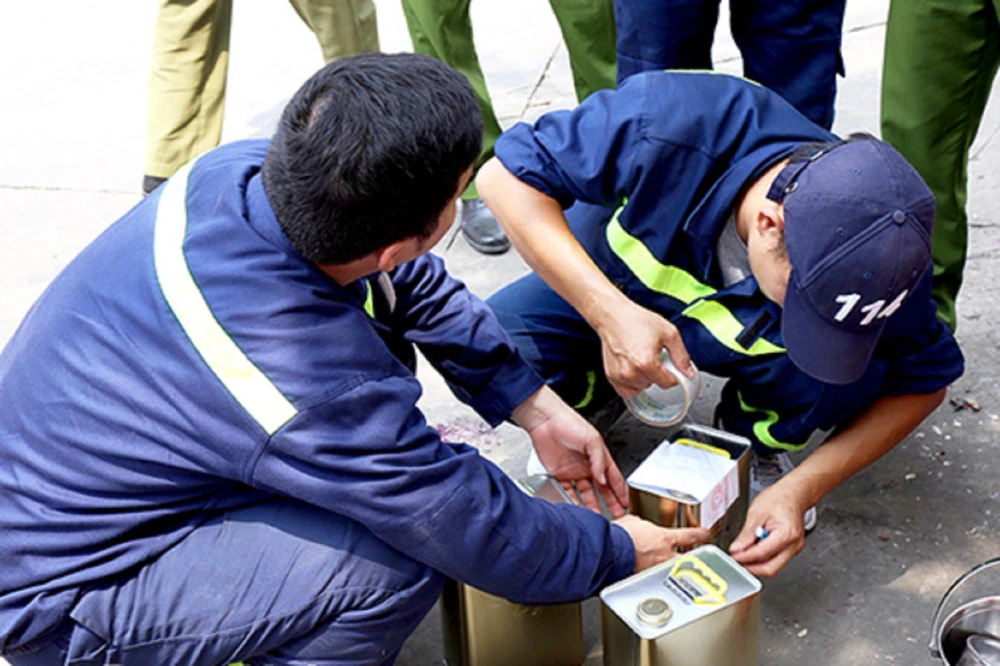 Công an lấy mẫu xăng của một cây xăng trong đường dây buôn lậu. Ảnh: VH
