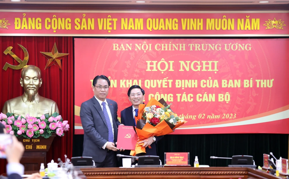 Phó Trưởng Ban Tổ chức Trung ương Phan Thăng An trao quyết định bổ nhiệm cho tân Phó Trưởng Ban Nội chính Trung ương Đặng Văn Dũng (phải). Ảnh: Phước H.