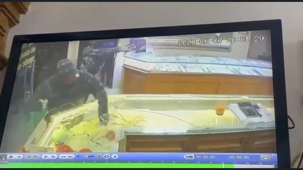 Tên cướp đập tủ kính vơ vét. Ảnh: Camera tiệm vàng Đức Nam. Tên cướp đập tủ kính vơ vét. Ảnh: Camera tiệm vàng Đức Nam.