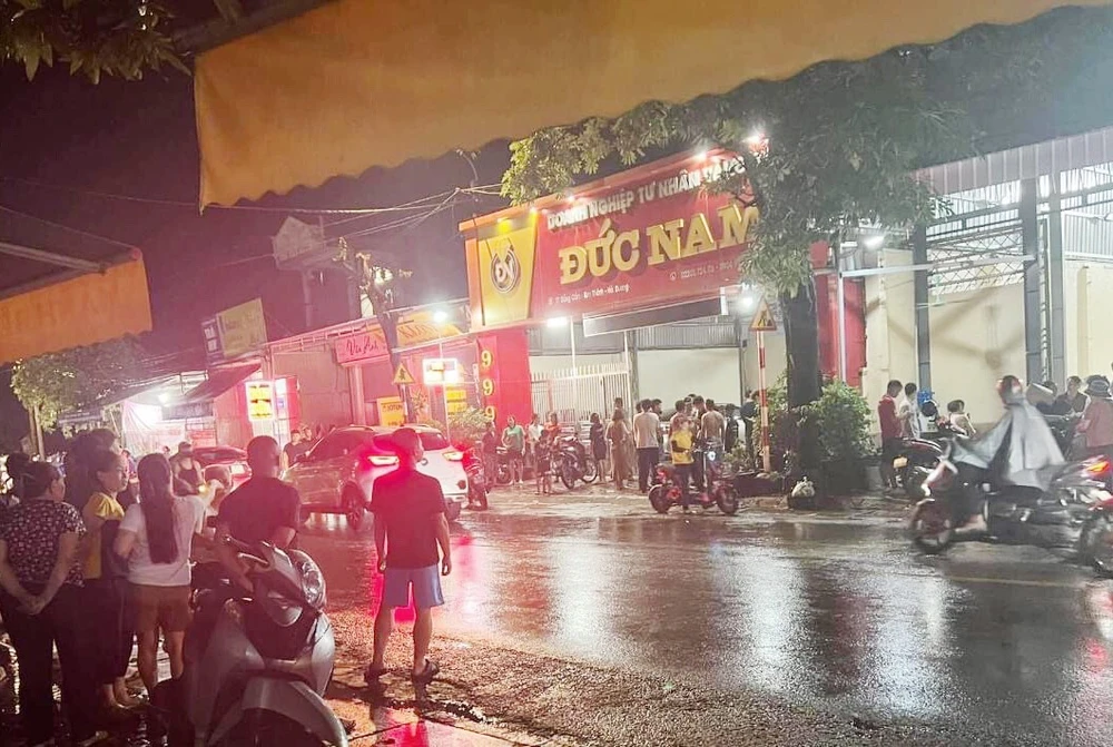 Người hiếu kỳ đứng giữa mưa quan sát tiệm vàng Đức Nam sau vụ cướp. Người hiếu kỳ đứng giữa mưa quan sát tiệm vàng Đức Nam sau vụ cướp.