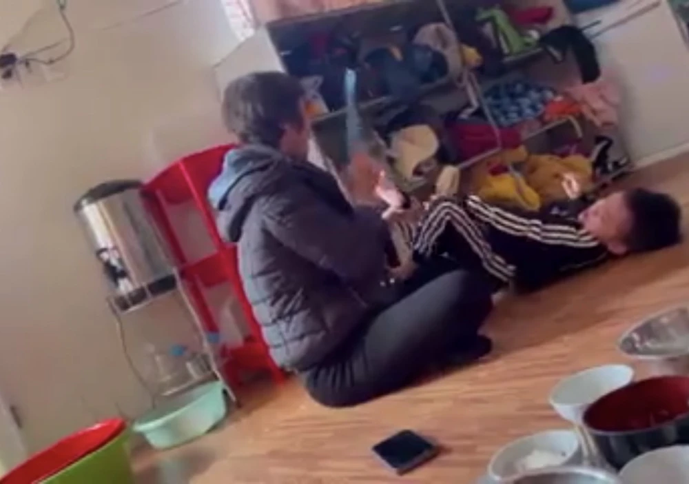 Cô giáo dùng lược đánh vào gan bàn chân học sinh tại cơ sở mầm non Hà My. Ảnh cắt từ clip.