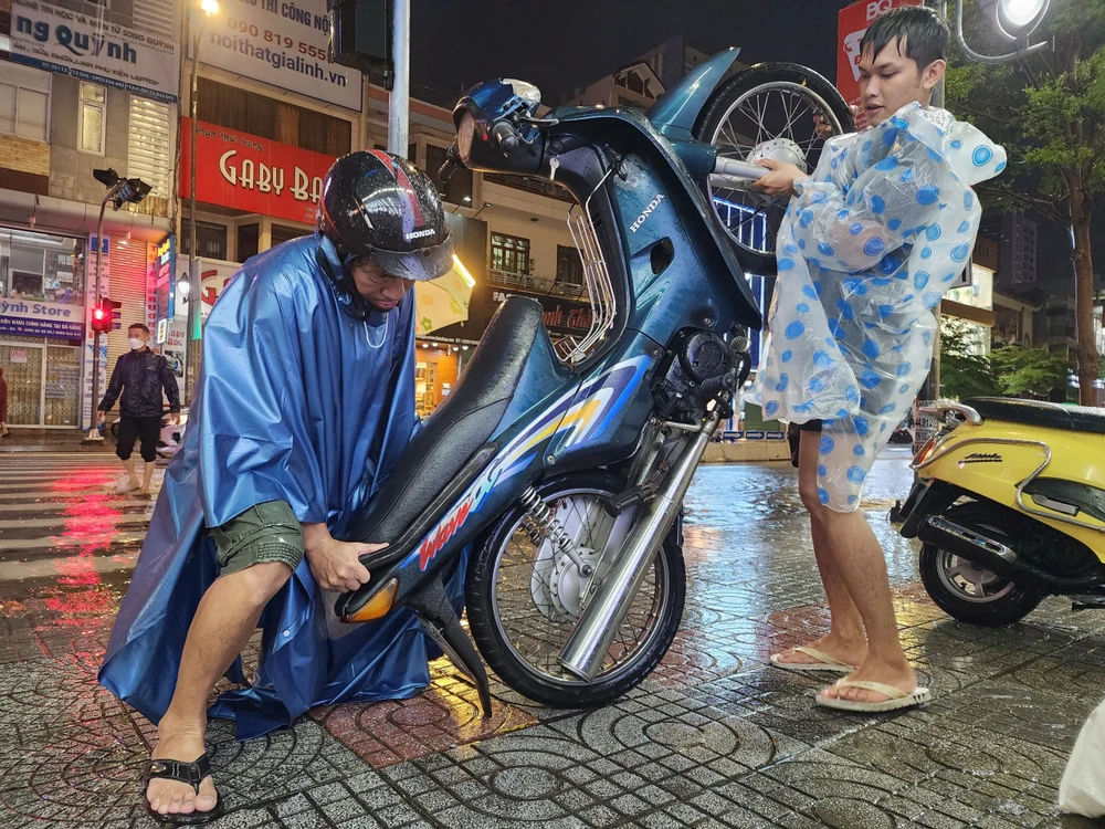 hai bo con dung xe may da nang ngap nuoc.jpg