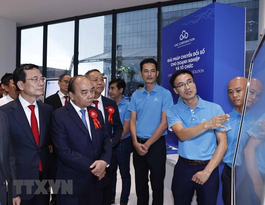 Chủ tịch nước Nguyễn Xuân Phúc và các đại biểu tham quan trưng bày, giới thiệu về các sản phẩm dữ liệu. Ảnh: TTXVN