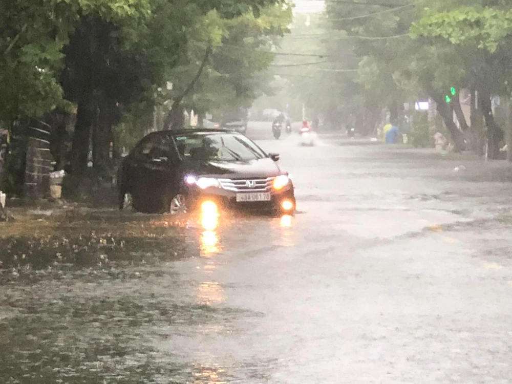 Nước ngập một phần bánh xe hơi. Ảnh: VĂN QUANG