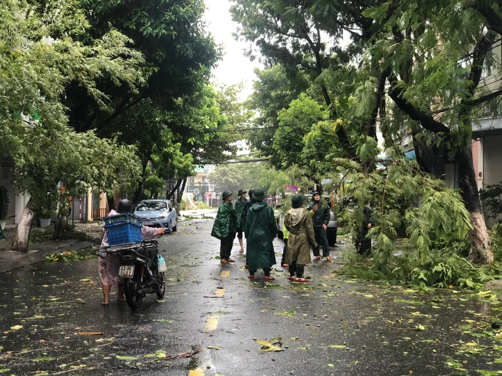 Lực lượng biên phòng, công an và điện lực đã ra quân dọn dẹp cây đổ. Ảnh: NGÔ QUANG Lực lượng biên phòng, công an và điện lực đã ra quân dọn dẹp cây đổ. Ảnh: NGÔ QUANG